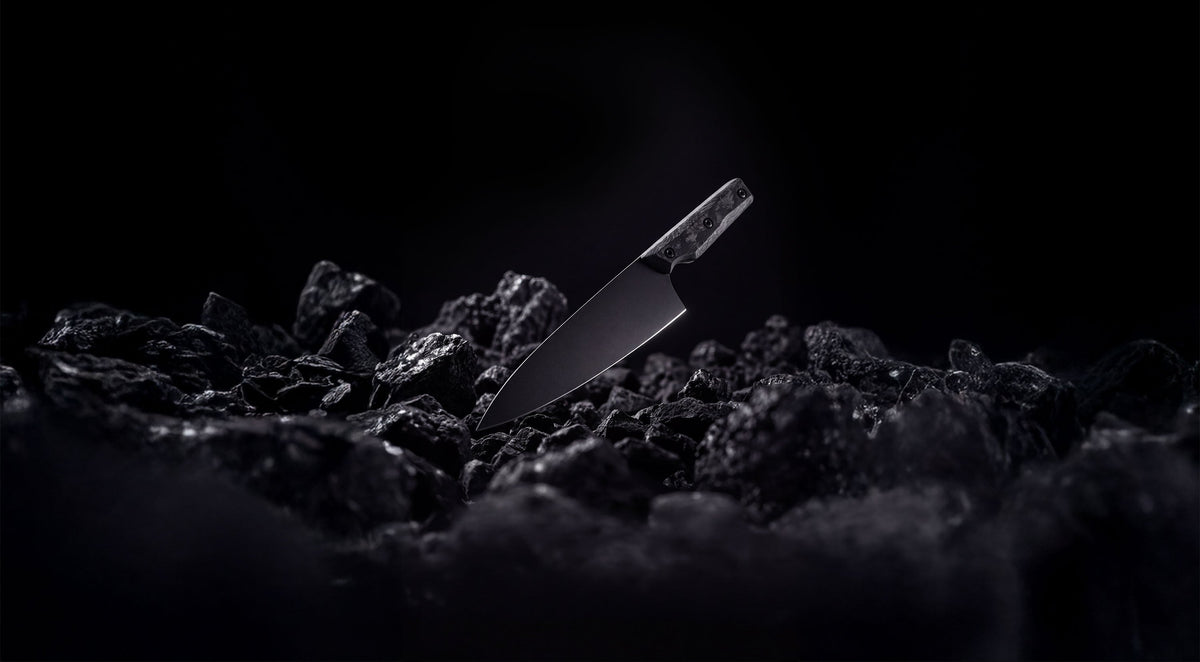 ONYX Series 8 inch chef knife resting on black coal